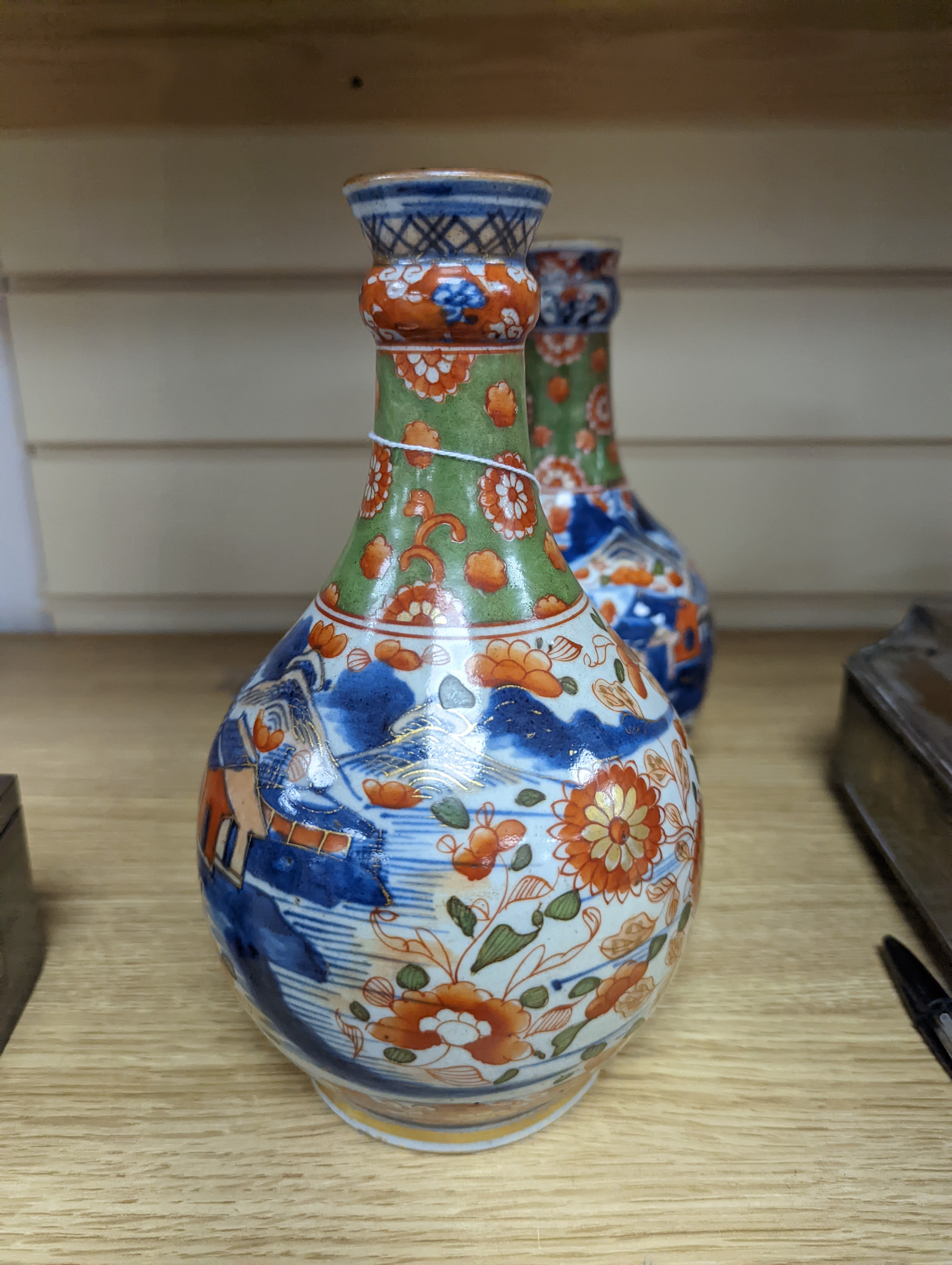 A pair of 18th century Chinese clobbered blue and white bottle vases 23cm